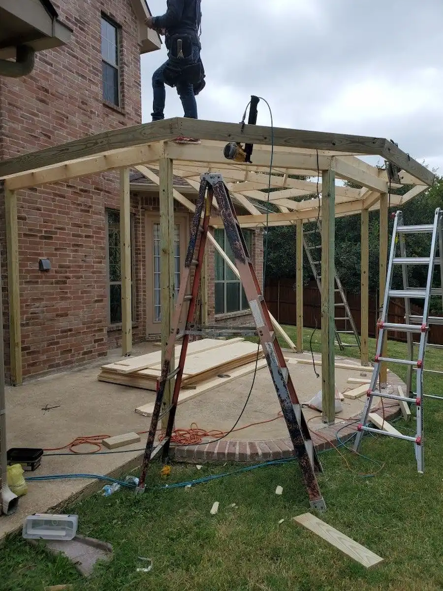 Covered patio construction with ladders and wood structure